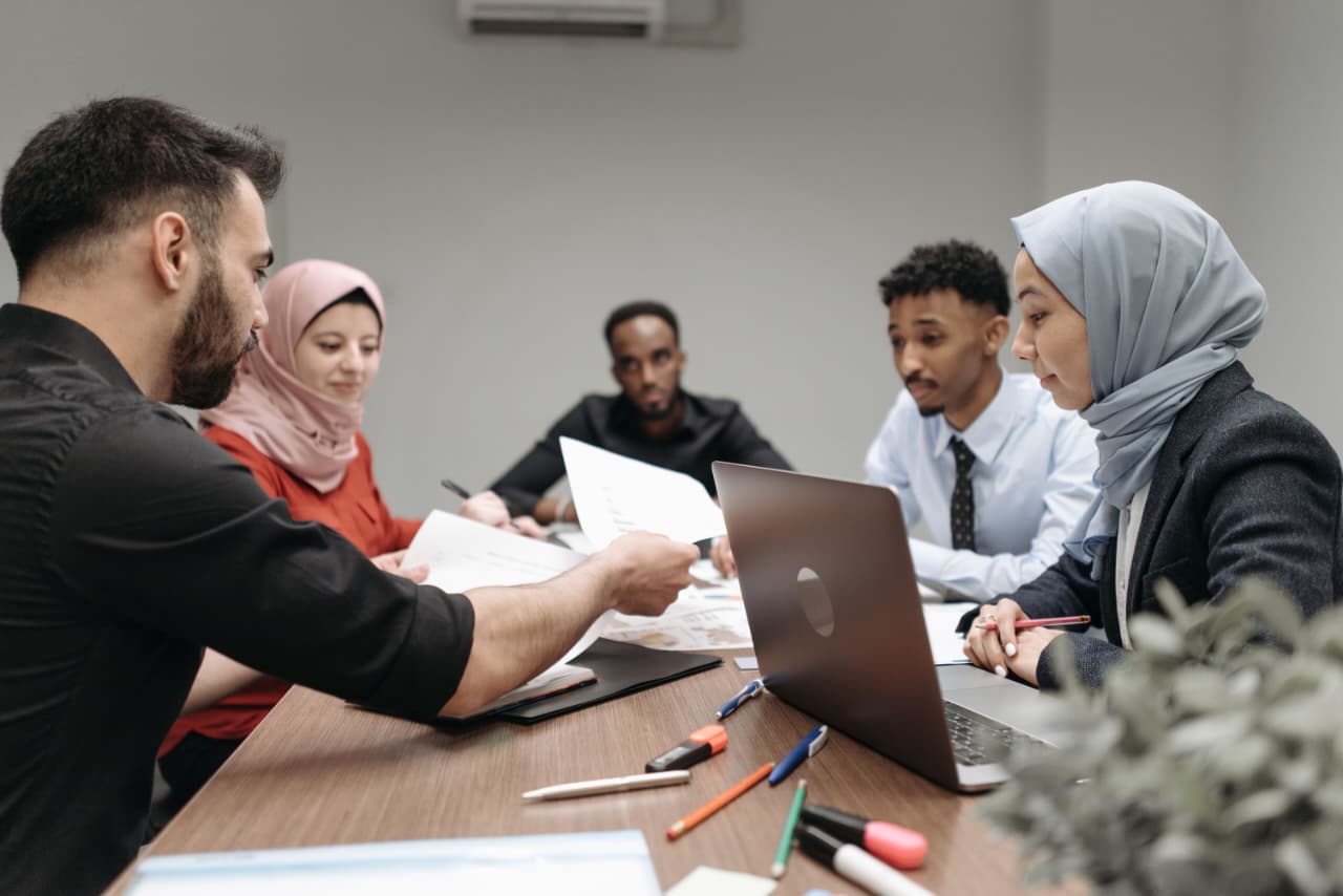Colleagues in a meeting reviewing documents together at a table